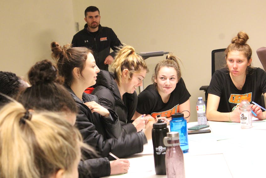 Cape Breton University soccer players Amelia Carlini, from left, Maddy Johnson, Rebecca Lambke and Emma Clark are shown during a team discussion on Saturday morning. The 2019 Atlantic University Sport champions were planning a 30-day health challenge that included improving their fitness and limiting their screen time. Shown in back is team performance analyst Mitchell Hanna. Both the men’s and women’s Capers soccer teams will look to defend their championship titles when the AUS season begins in September. ERIN POTTIE/CAPE BRETON POST