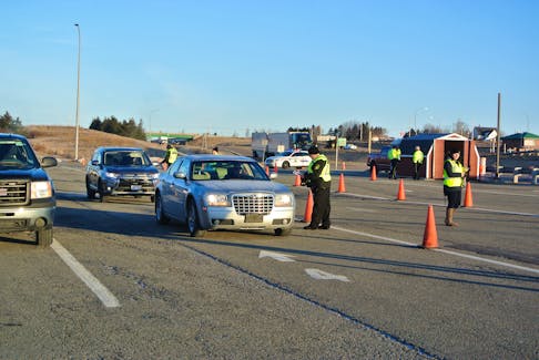 Provincial officials question motorists as they enter Nova Scotia at the inbound weigh scale in Fort Lawrence last week. RCMP assisted provincial officials as they tighten the border as a result of the province’s state of emergency declaration. Darrell Cole – Amherst News