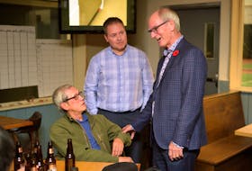 Cecil Villard chats with supporters Tunglam Tran, left, and Marcel Arsenault at his headquarters in Charlottetown on Monday, Nov. 5, 2018.