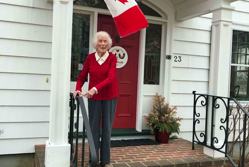 Joy Saunders, 101, stands outside of her Lunenburg home, beneath a Canadian flag raised to show support for the country's fight against COVID-19.
