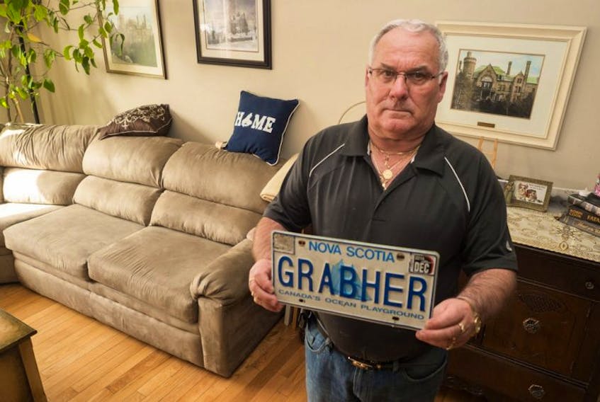 Lorne Grabher holds his license plate which he is no longer allowed to have on his car because of the spelling of his last name. March 23, 2017. Chronicle Herald photo.