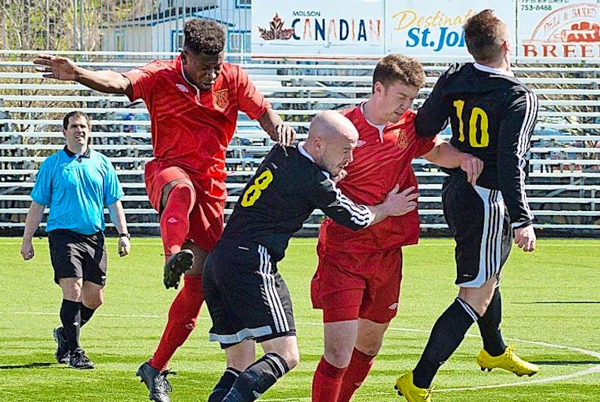 Holy Cross players Thomas Kargbo (left) and Owen McAleese and Mount Pearl’s Taedy O'Rourke (8) and Scott Woodfine (10) go up for a ball during Molson Challenge Cup soccer action at King George V Park in St. John’s on Sunday. Defending league champion Holy Cross won 2-0.