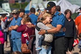 Elysbeth Major, left, embraces her husband Leading Seaman Kelly Perron and daughter Emila Perron before he departs on the HMCS Charlottetown on Monday.