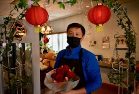 Larkin Lin, owner of Paul's Flower Shop on University Avenue in Charlottetown, holds a bouquet of roses in his store on Valentine's Day.