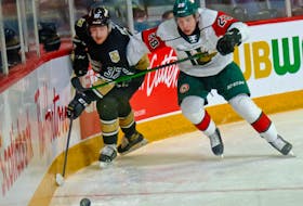 Charlottetown Islanders winger Bailey Peach, left and Halifax Mooseheads defenceman Stephen Davis battle for a loose puck during Sunday's Quebec Major Junior Hockey League contest in Halifax.
