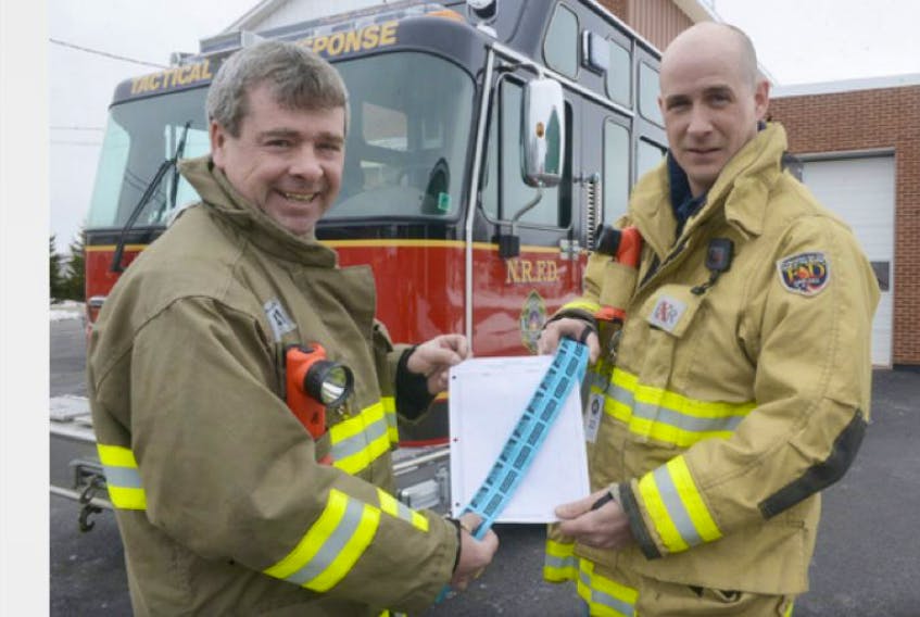 <span class="COLOURKicker">Dean Smith, left, a lieutenant with the North River Fire Department and chief Anson Grant hold a roll of tickets for the Chase the Ace draw being held in collaboration with the Kingston Legion. The draw has created a big buzz in the community, with firefighters selling the tickets in a makeshift drive-thru at the department every Saturday.</span>
