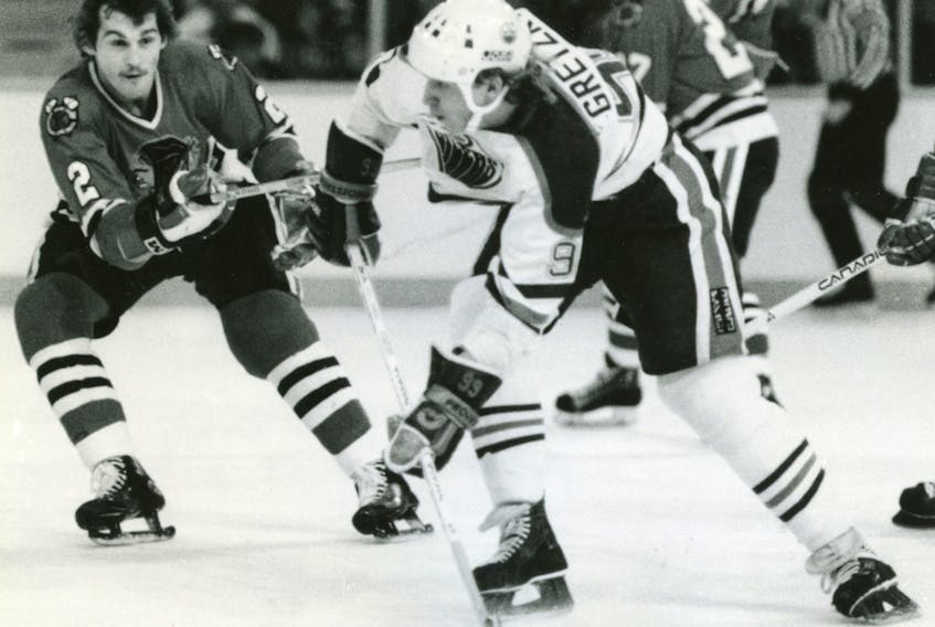 Wayne Gretzky skates with the puck against Chicago Blackhawks defenceman Greg Fox during an NHL playoff game in May 1983.