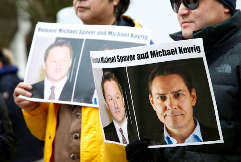  People hold signs calling for China to release Canadian detainees Michael Spavor and Michael Kovrig during an extradition hearing for Huawei Technologies Chief Financial Officer Meng Wanzhou at the B.C. Supreme Court in Vancouver, in March 2019.