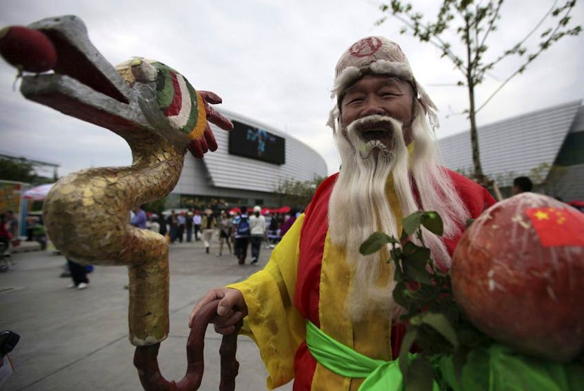 A man depicting the God of Longevity, one of the Chinese Three Lucky Gods through the site at the Shanghai World Expo Saturday May 8, 2010 in Shanghai, China.
