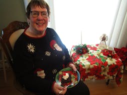 Marlene Bryenston sits in the living room of her home in P.E.I. with a slice of her Chocolate Hot Fudge Upside Down Cake, which she says calls "gooey delicious". CONTRIBUTED 