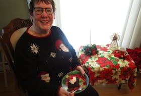Marlene Bryenston sits in the living room of her home in P.E.I. with a slice of her Chocolate Hot Fudge Upside Down Cake, which she says calls "gooey delicious". CONTRIBUTED 