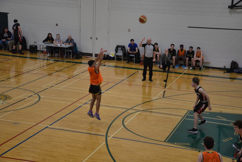 The Three Oaks Axemen’s Justin Caron is about to get a shot off while being guarded closely in the paint during P.E.I. School Athletic Association action against the Montague Vikings in Summerside recently.
