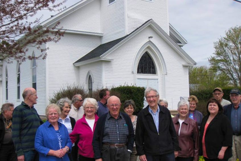 Glenn Ells and Dr. Robert Wallace are in the centre of a happy group of worshippers who have just purchased the former Trinity United Church in Upper Canard.