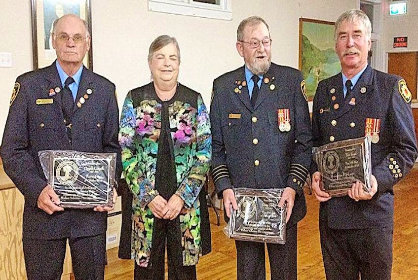 Coun. Lynne Welton presents 40-year service awards to Wallace firefighters (from left) Gerald Langille, Doug Gullon and Tim Boyd during the department’s annual banquet.