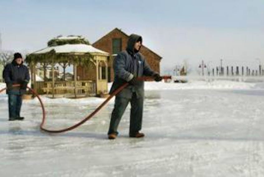 ['In this Guardian file photo, Charlottetown parks and recreation worker Ken Flanagan holds the hose steady for Todd Steele as he floods the rink near Founders Hall.']
