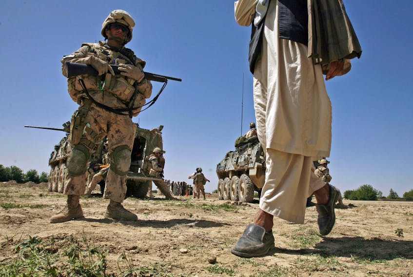 WO Dany Boudrault watches closely as an Afghan man leaves his area following payment for work done on a Canadian sponsored project in the Zhari district of Kandahar province in 2007. - Photo by Christian LaForce