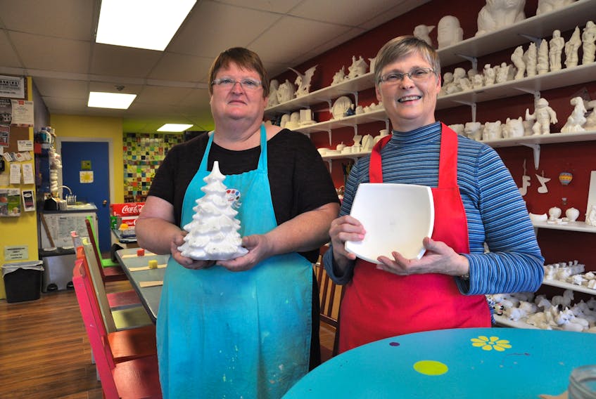 Linda Barkhouse, right, owns Wolfville’s Clayground studio alongside her sister, Melanie Godon. They each hold a ceramic mold designed by their grandmother, with whom they used to make ceramics when they were kids. The sisters have decided to sell their business but will remain open until it is sold.