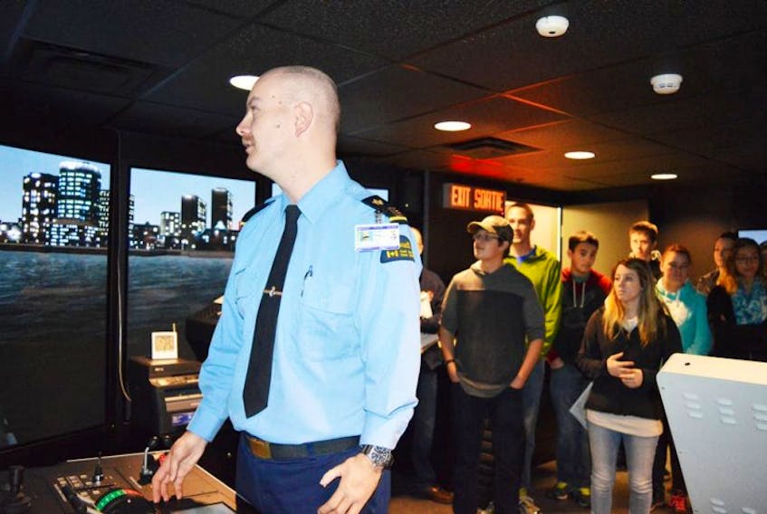 Phillipe Campbell demonstrates the navigation simulator to visiting students at the Canadian Coast Guard College on Friday. The event simulates a coast guard vessel in various situations on the ocean. The demonstration was part of the 50th anniversary open house at the college.