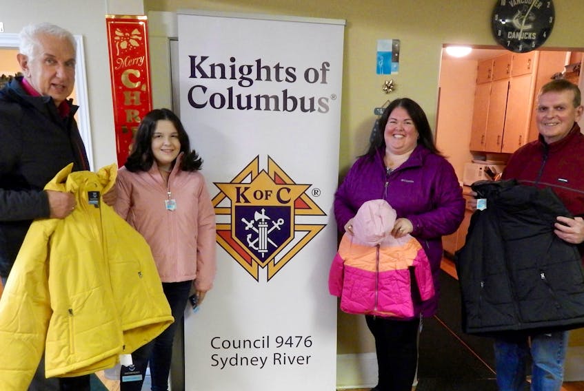 Grand Knight Charlie Aboud of the Sydney River Knights of Columbus made a donation of four boxes of coats to the Society St. Vincent de Paul for distribution to families and individuals in need. The Coats for Kids drive is held annually by the KOC across North America. From left, Aboud, coat model Jocelyn MacQueen, and the society’s Michell Finigan and Bill Small. CONTRIBUTED • ALBERTA MACKINNON