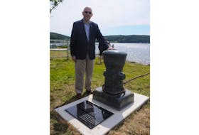 Irish artist Padraig Tarrant stands beside a stone sculpture unveiled in Heart's Content Thursday to commemorate the transatlantic telegraph cable. He created a matching piece for Valentia Island, Ireland.