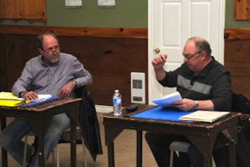 ["New Deputy Mayor Kevin Connolly, right, shares some words with Coun. Rod Delaney, left, and other council members at the beginning of Tuesday's meeting in Cupids."]