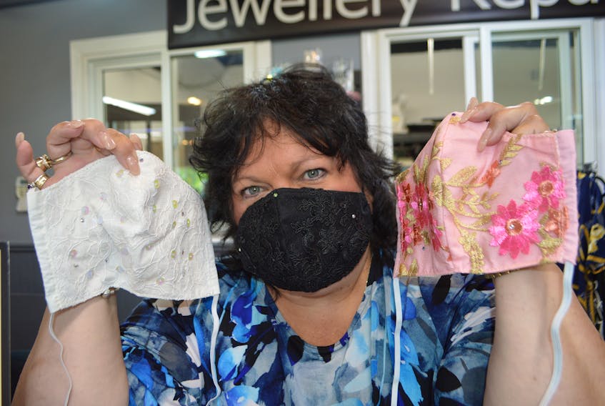 Kim Boudreau of Sydney, owner of Kreative Design at the Value Check Plaza in Sydney River, holds up face masks she has designed with lace and bling. Sharon Montgomery-Dupe • Cape Breton Post