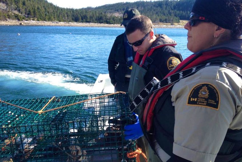 <p>Fisheries officers Chris Wagner and Jacklyn Bolivar prepare to return a trap to the water after a compliance check.</p>