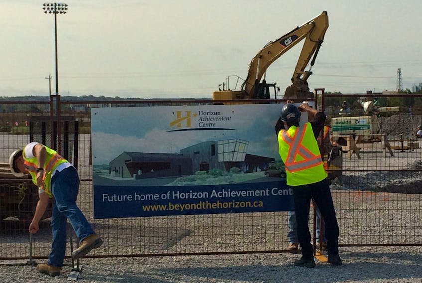 In preparation for a picture with the assembled dignitaries, workers erect a sign declaring the new site for the Horizon Achievement Centre. Construction has begun on the $7 million facility located in the Sydney’s Harbourside Commercial Park. CAPE BRETON POST PHOTO