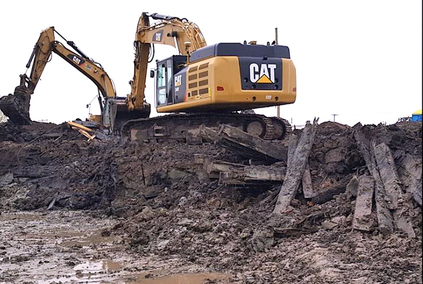 Dozens of railroad ties were found underground when crews started digging the flood mitigation pond to clean up the contaminated soil, adding to the weight of the material that is being trucked away.