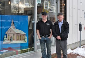 Chris Buckle (left) and his dad, David Buckle, recently worked together to bring new life to a giant Christmas greeting card David made 55 years ago. The wooden card is on display at Picture it in a Frame on West Street in Corner Brook. The shop is owned by Chris.