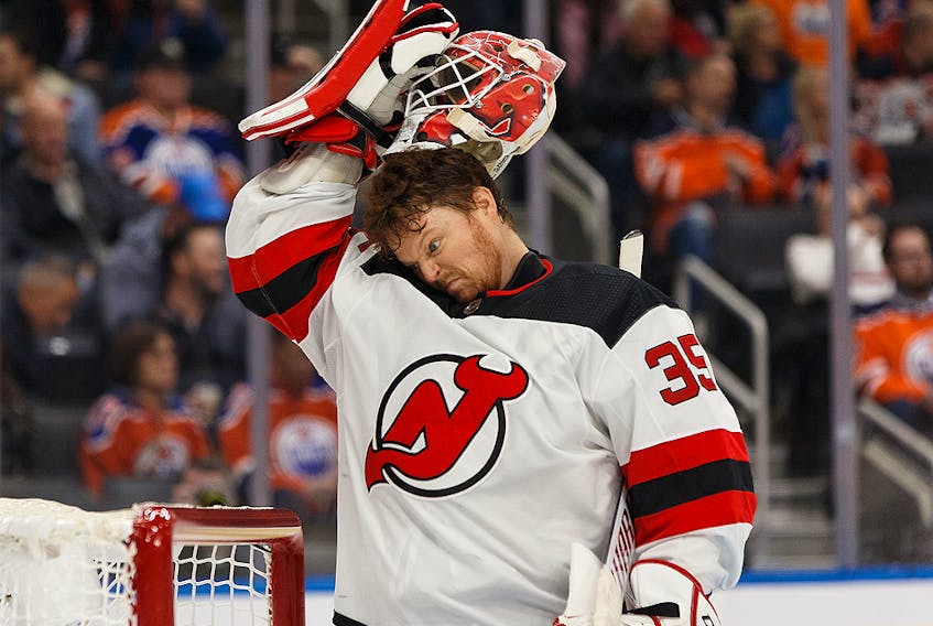 New Jersey Devils goalie Cory Schneider makes a funny face as he pulls his mask on to face the Oilers at Rogers Place in Edmonton on Nov. 8.