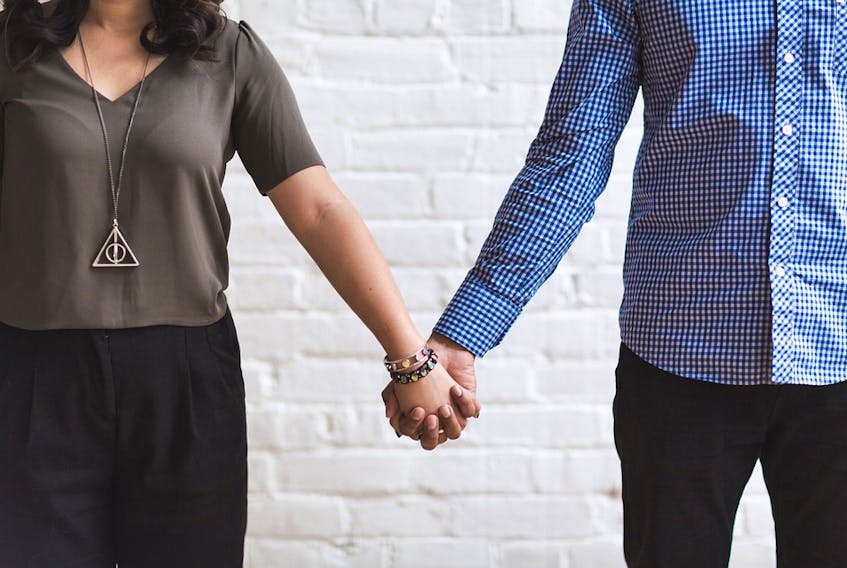 Stock image from pixabay.com of couple holding hands.