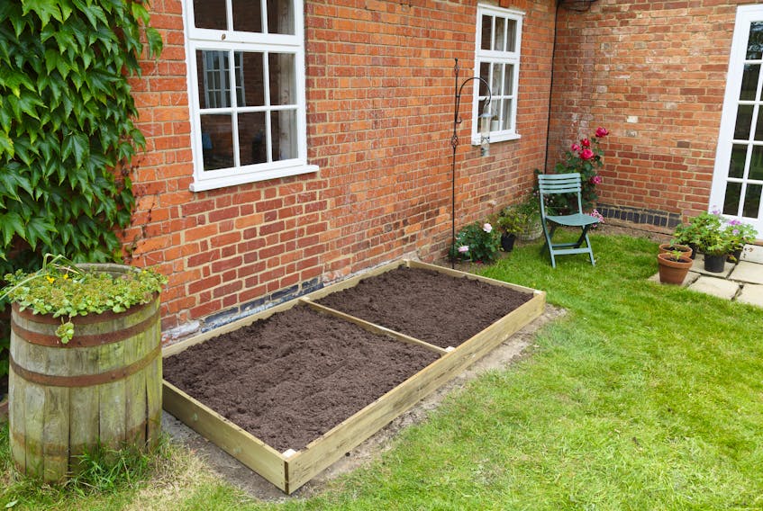 A new empty raised bed in a kitchen garden is filled with soil ready to plant. CONTRIBUTED