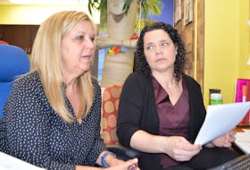Monique MacMullin, left, and Tina Baldwin, travel consultants with Maritime Travel on Charlotte Street in Sydney, work on trying to change travel plans for a client. Sharon Montgomery-Dupe/Cape Breton Post



