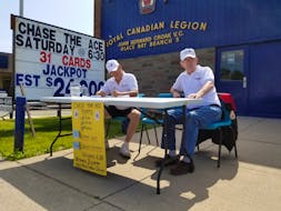 In this file photo from July 2019, Bob Mounce, left, and Bill McCann sit outside John Bernard Croak Elementary School  selling tickets for the Glace Bay Legion’s first Chase the Ace fundraiser, which raised $218,000. The legion is currently holding its second Chase the Ace fundraiser but is unsure how they’re going to conduct the weekly draw now that COVID-19 precaution measures are in effect in Nova Scotia. CAPE BRETON POST PHOTO  