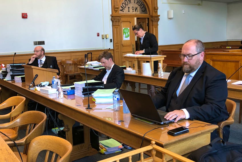 Lawyers (L-R) Mark Sheppard, Justin Mellor and Don Anthony, who are representing the provincial government and Chief Medical Officer of Health Dr. Janice Fitzgerald in a legal challenge of the COVID-related travel ban, sit to await Justice Donald Burrage after a recess in Newfoundland and Labrador Supreme Court Tuesday morning. Behind them is lawyer Rosellen Sullivan, who is representing the Canadian Civil Liberties Association in the challenge. 