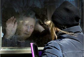 A woman visits her 86-year-old mother through a window at the Orchard Villa long-term care home in Pickering on Wednesday April 22, 2020. The Pickering home was one of the homes included in a shocking report by the Canadian military, released Tuesday by the province, regarding the status of five homes in Ontario. 