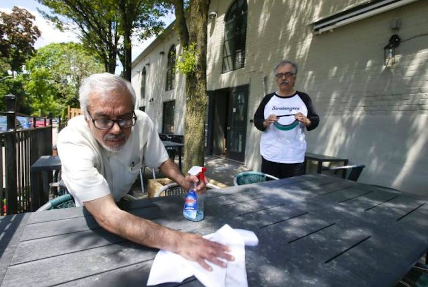  The owners of Stratengers Restaurant and Bar (Dharam Vijh(L) and his brother Anil prepare their patio section for reopening on Thursday June 4, 2020 in Leslieville.