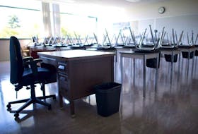 CP-Web. An empty teacher's desk is seen at the front of an empty classroom at McGee Secondary school in Vancouver.