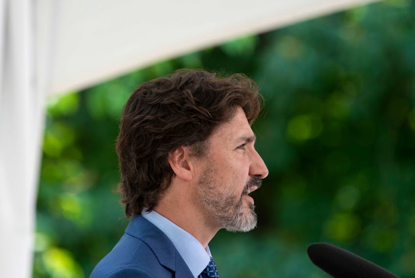 Prime Minister Justin Trudeau responds to a reporter's question during a news conference outside Rideau Cottage in Ottawa, after announcing a program aimed at encouraging students to volunteer, on June 22.