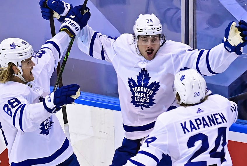 Toronto Maple Leafs' Auston Matthews (34) celebrates his game winning goal against the Columbus Blue Jackets' with teammates William Nylander (88) and Kasperi Kapanen (24) during overtime NHL Eastern Conference Stanley Cup playoff action in Toronto on Friday, August 7, 2020. 