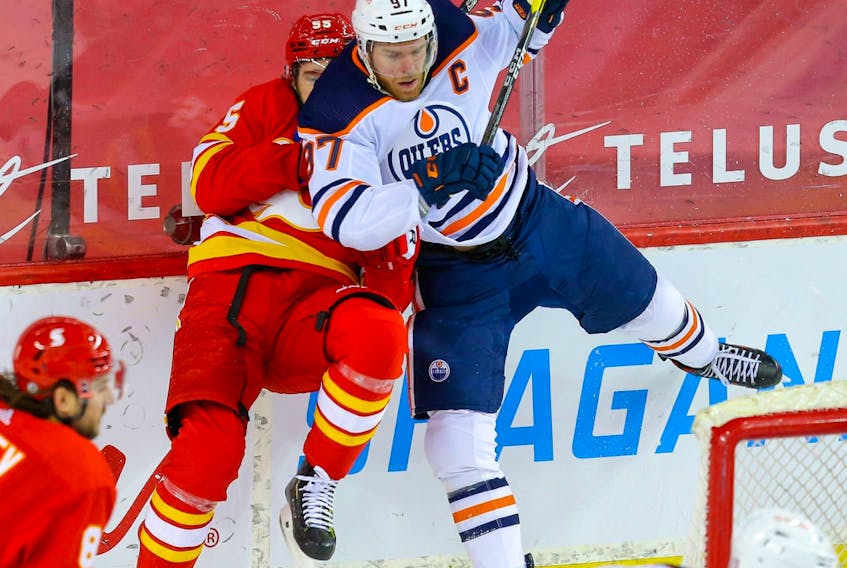 Calgary Flames' Noah Hanifin collides with Connor McDavid of the Edmonton Oilers in Calgary on March 15, 2021.