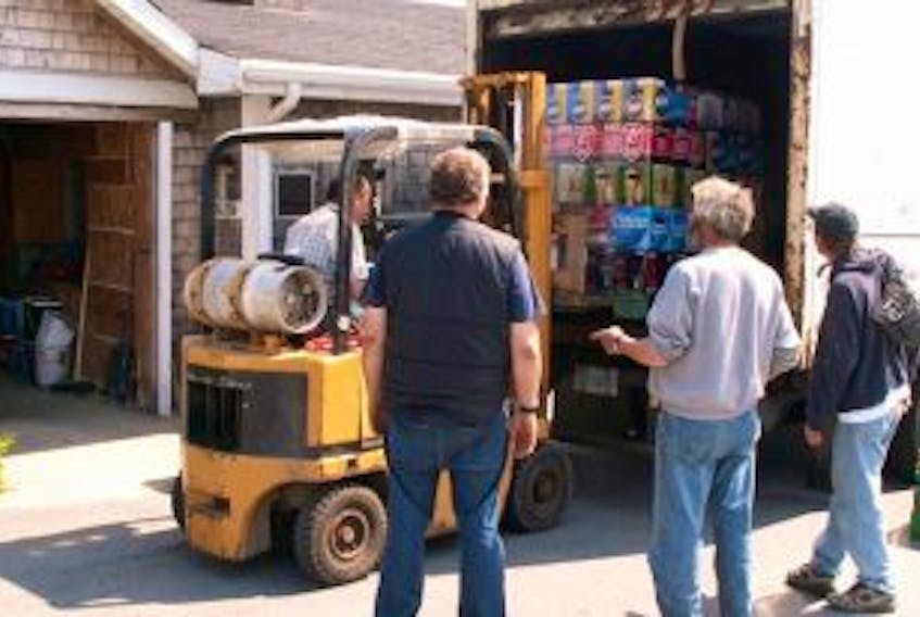 ['Curious onlookers gathered to watch the first load of beer come off the truck and into Brier Island’s new NSLC agency store. Jonathan Riley photo']
