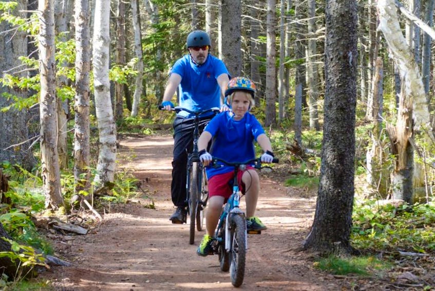 Vaughan Lloyd, front, and Simon Lloyd enjoy a ride on the cycling trail at Robinsons Island in the Prince Edward Island National Park Saturday.