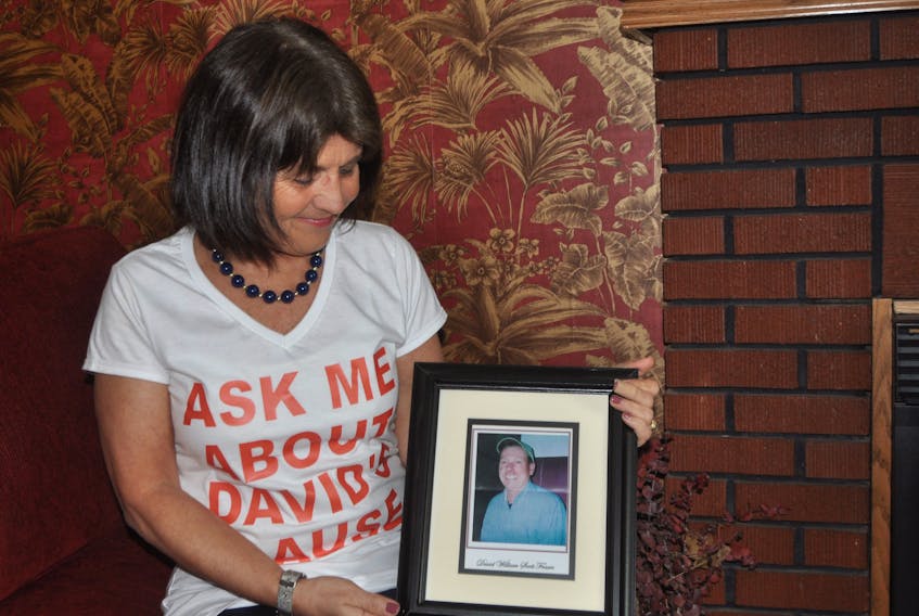 Kathy MacNaughton holds a photo of her late partner David Fraser.  FILE PHOTO/ADAM MACINNIS