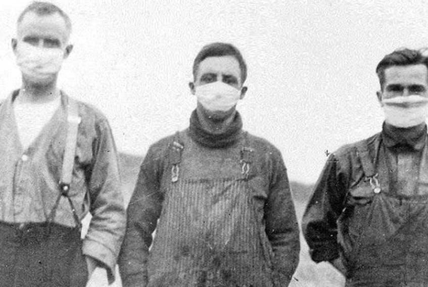 Three Alberta men are shown wearing masks to protect themselves during the Spanish influenza pandemic. The Spanish flu killed between 30,000 and 50,000 Canadians and as many as 40 to 50 million globally between 1918 and 1920. Library Archives of Canada photo