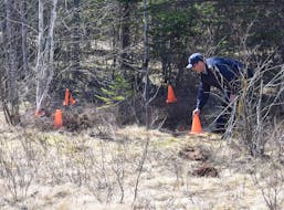 RCMP Sgt. Andrew Buckle marks off a crime scene on Plains Road in Debert as part of the mass shooting investigation. 