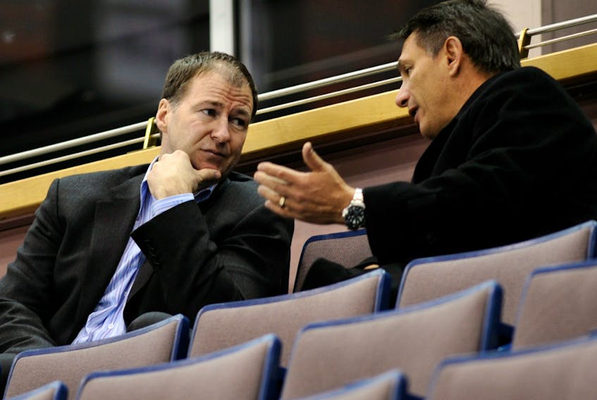 Edmonton Oilers executive Kevin Lowe, left, speaks with then-Detroit Red Wings general manager Ken Holland in this file photo taken in Edmonton on Feb. 26, 2008. The two are part of the 2020 Hockey Hall of Fame class.