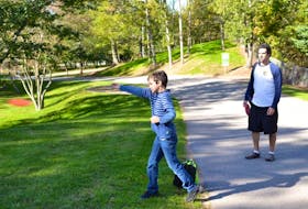 <p>Zane Ansara, nine, gets some tips on the disc golf course in Lockhart Ryan Park in New Minas from his father, John.&nbsp;</p>
