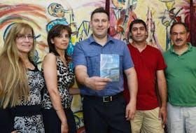 <p>Members of the Canadian Lebanese Association of P.E.I. executive show a copy of the documentary “A New Place Called Home” before a screening in Charlottetown Saturday. In this photo is, from left, Olinda Gossen, Karen Zakem, president Fadi Rashed, Robert Mansour and Fouad Haddad.&nbsp;</p>